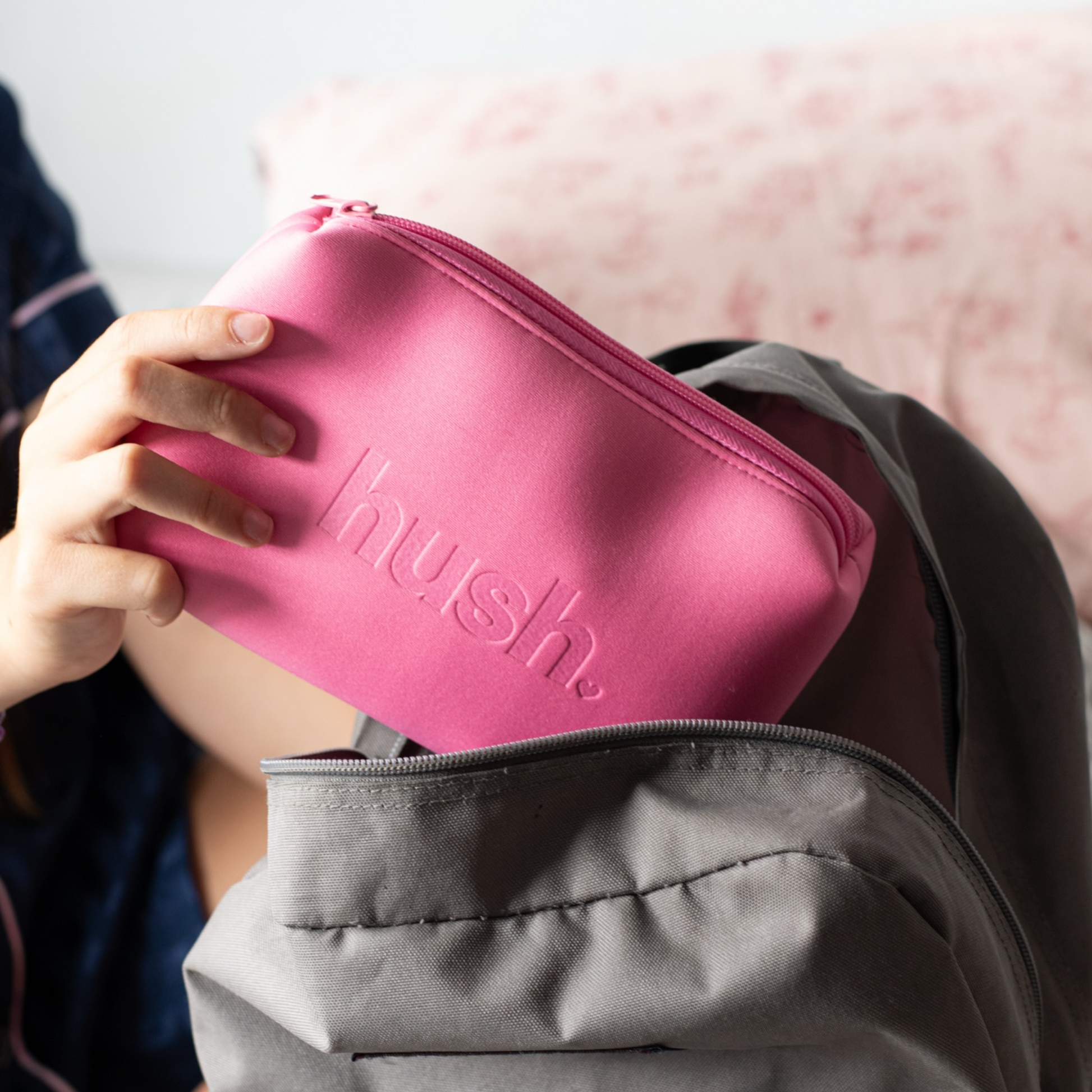 Pink hush purse being put into school bag