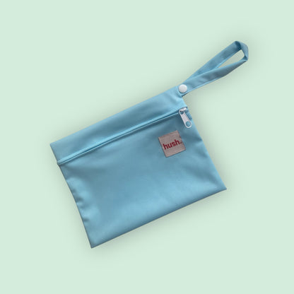 Blue wet bag with hush branding on pale blue background.