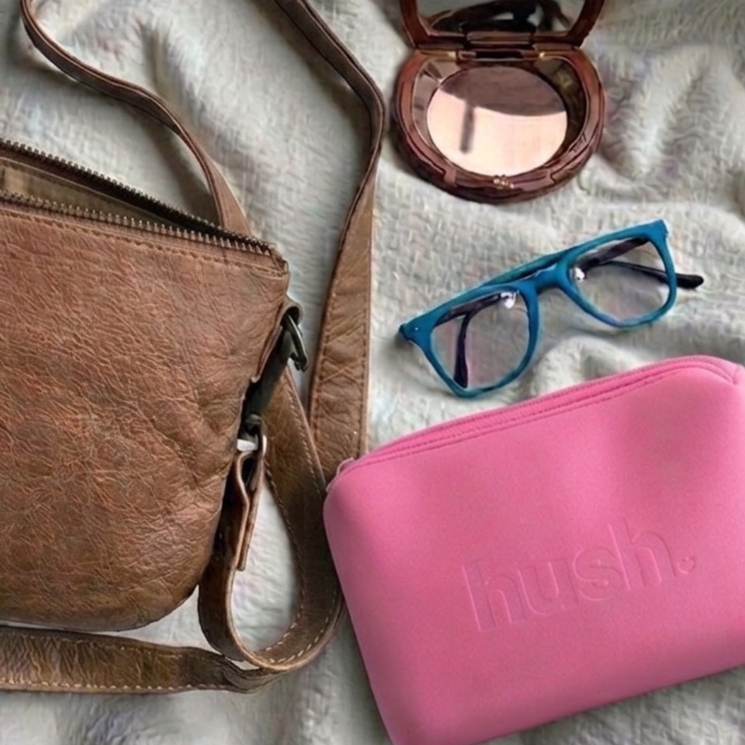 Pink period kit next to a leather handbag