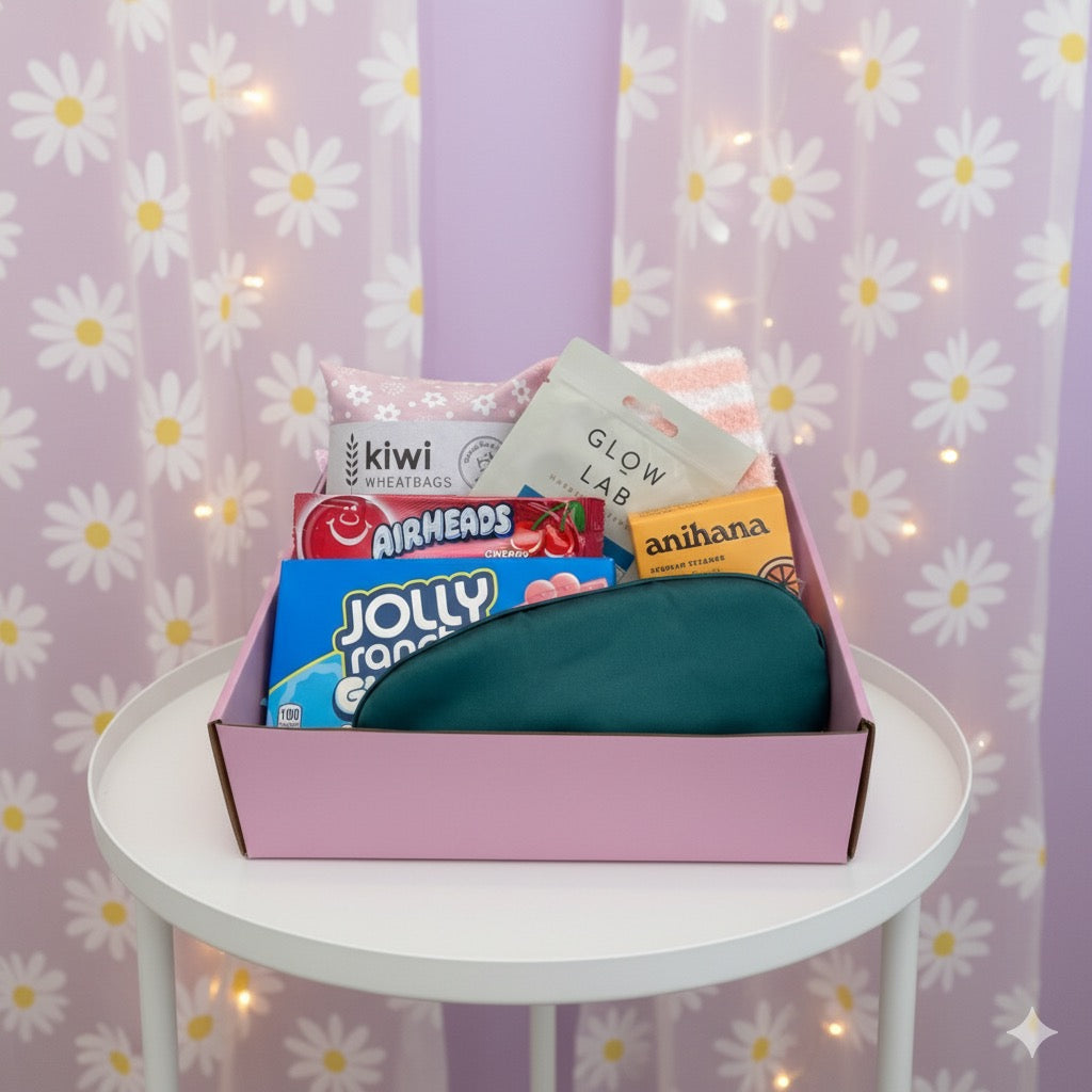 Beautiful gift box displaying items inside, Kiwi wheat bag, fluffy socks, face mask, airheads candy, anihana shower steamer, jolly rancher candy and eye mask. 